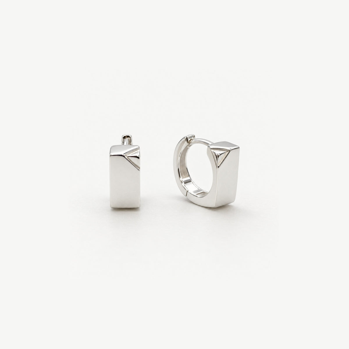 Pair of small sterling silver huggie hoop earrings with a polished rectangular front and a triangular faceted corner