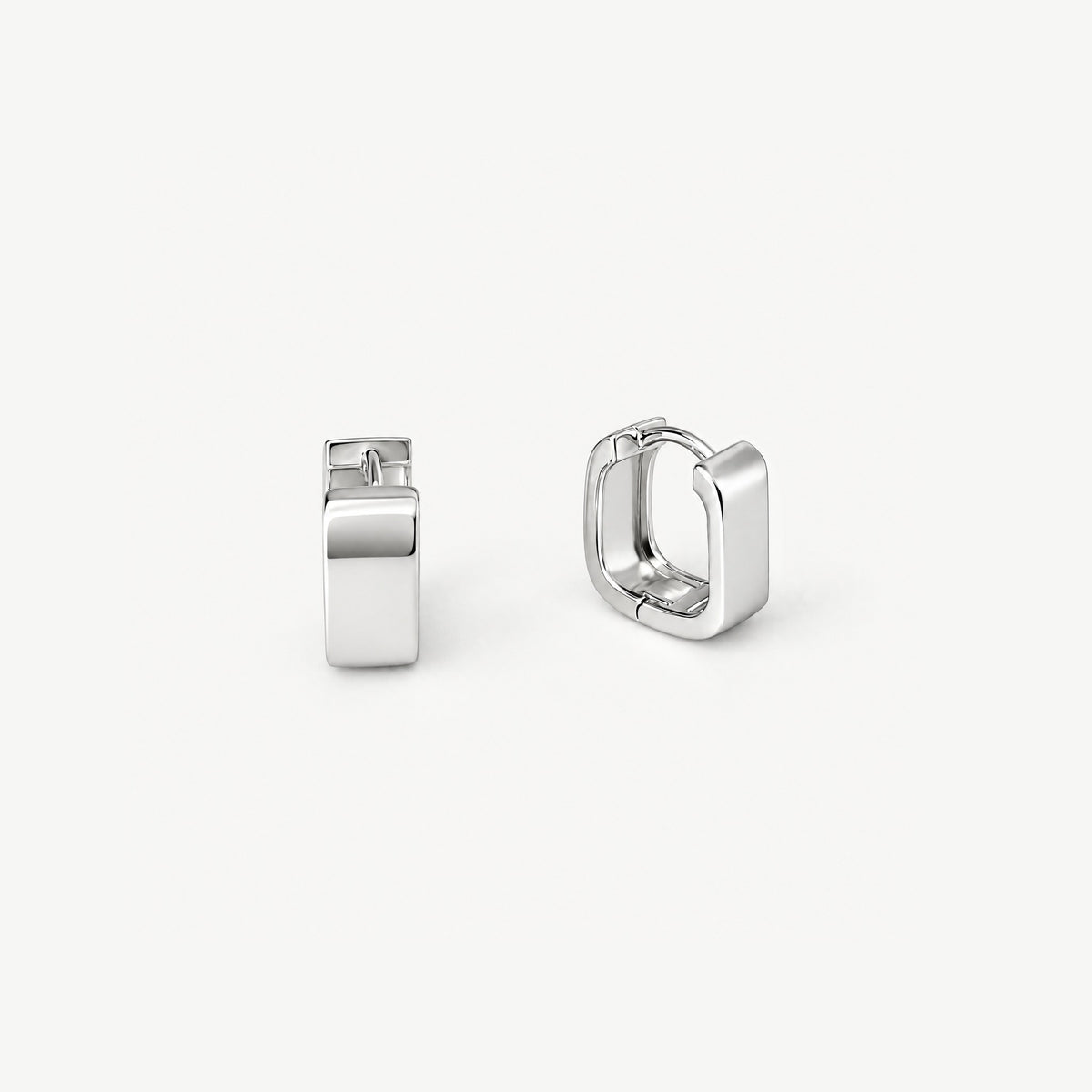 Pair of square huggie hoop earrings in white gold-plated sterling silver, one facing forward, one turned to show inside