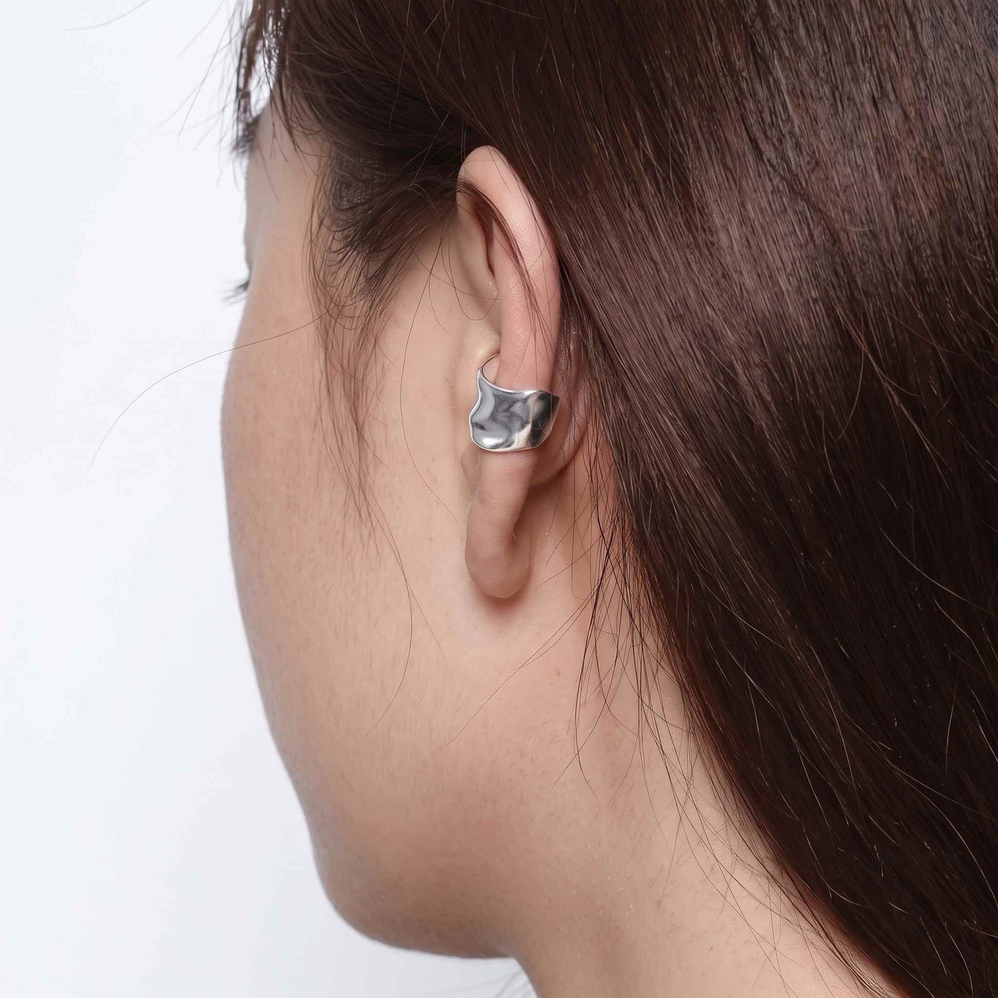 Wide sterling silver ear cuff worn on the lower ear rim, shown in profile with hair tucked back