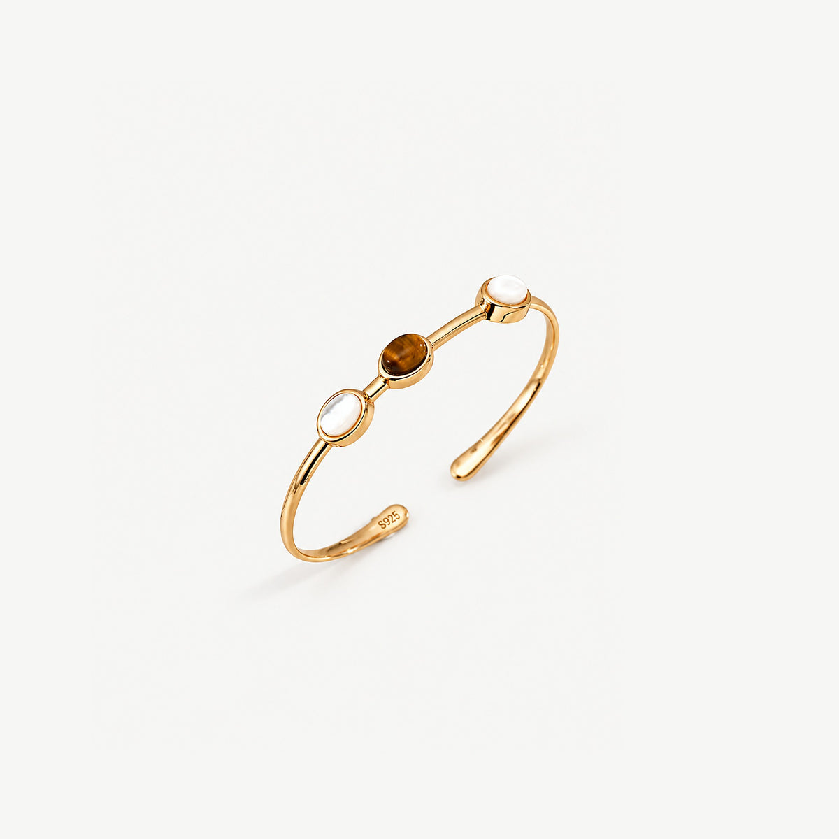 Gold-plated tiger eye cuff bracelet at an angle, showing the slim band, three oval settings and the 925 stamp